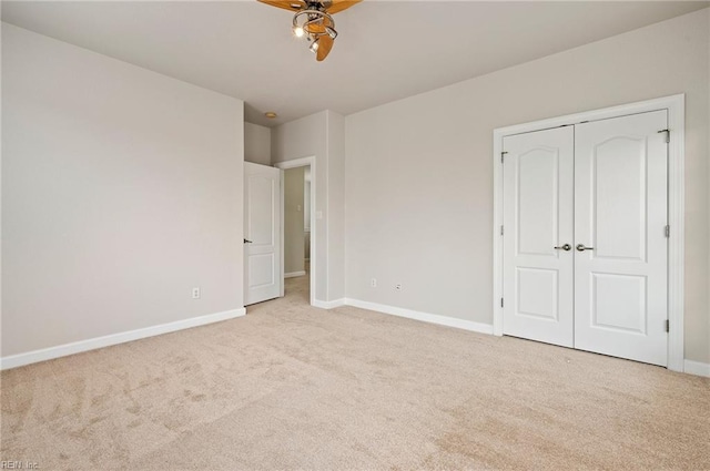 unfurnished bedroom with baseboards, carpet floors, a closet, and ceiling fan