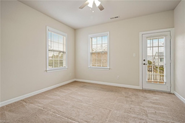 spare room with visible vents, carpet flooring, baseboards, and ceiling fan