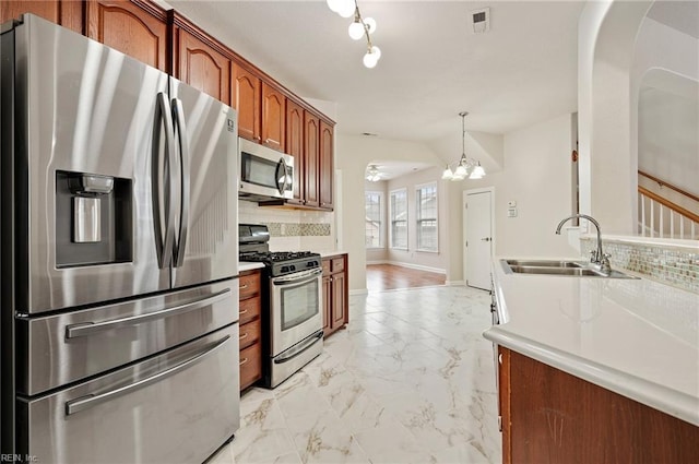 kitchen featuring visible vents, marble finish floor, a sink, backsplash, and appliances with stainless steel finishes