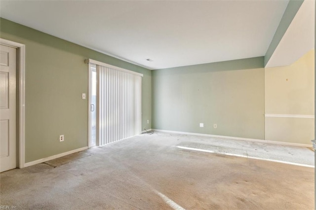 carpeted empty room featuring baseboards