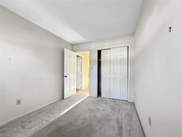 unfurnished bedroom featuring carpet flooring, baseboards, and a closet