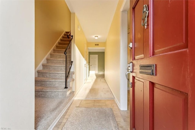 interior space featuring stairs, light tile patterned floors, and baseboards