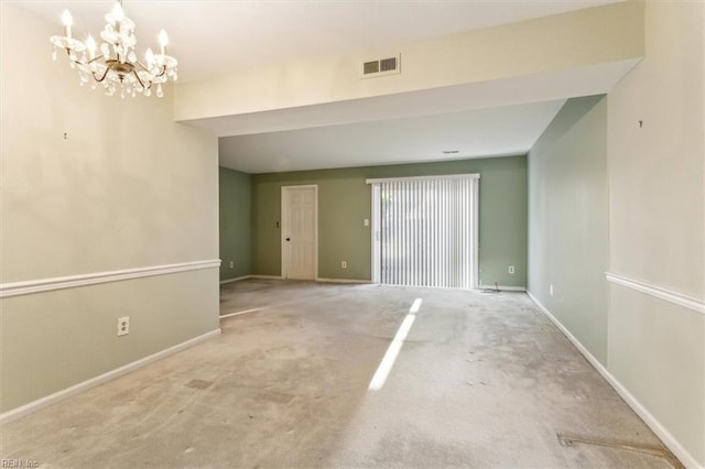 unfurnished room featuring carpet, an inviting chandelier, baseboards, and visible vents