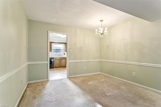 carpeted spare room with a sink, baseboards, and a chandelier