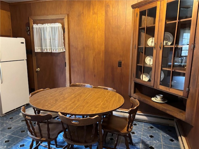 dining room with a baseboard heating unit and dark tile patterned floors