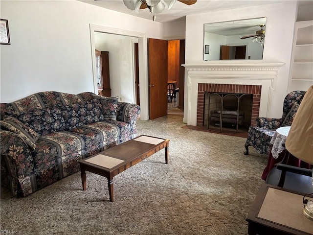 carpeted living area featuring a brick fireplace and ceiling fan