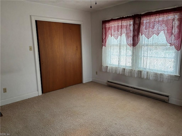 interior space with a baseboard radiator, baseboards, carpet, and a closet