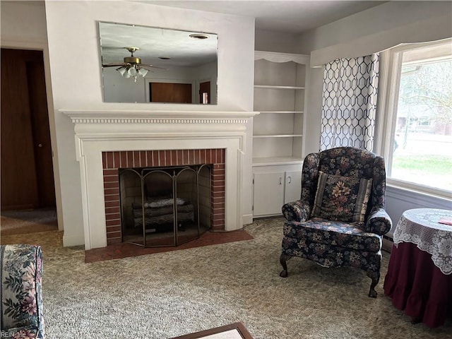 carpeted living area featuring a fireplace and a ceiling fan