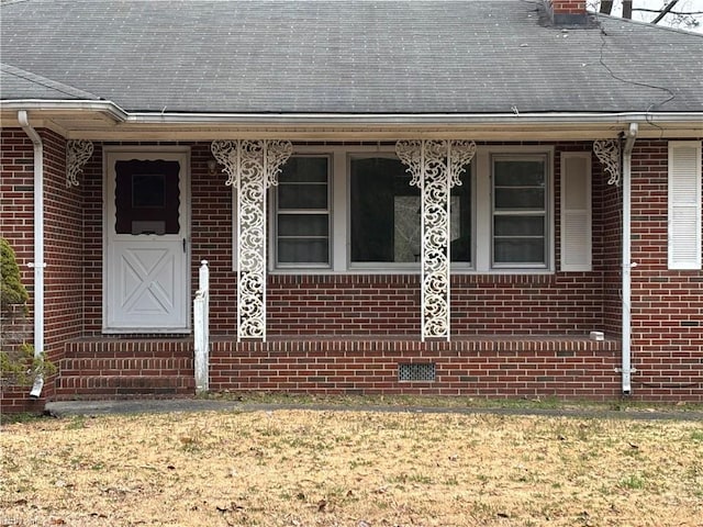 property entrance with brick siding and a shingled roof