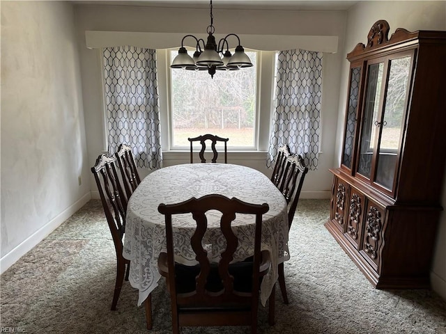 carpeted dining area with a notable chandelier and baseboards