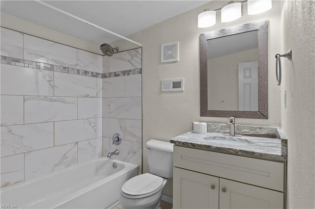 bathroom featuring visible vents, toilet, bathing tub / shower combination, a textured wall, and vanity