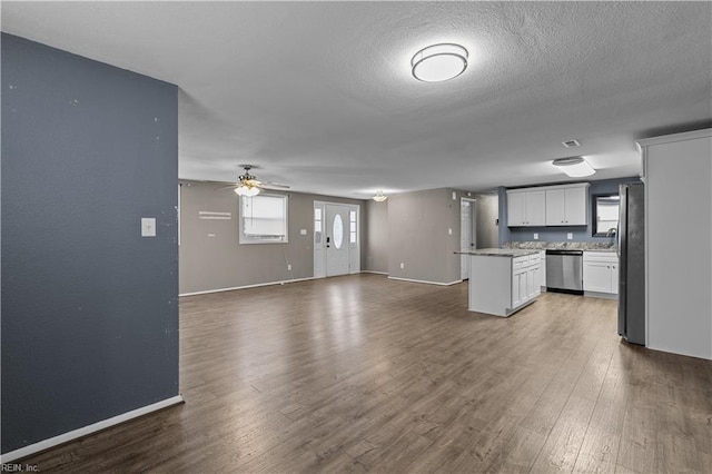 kitchen with a kitchen island, dark wood finished floors, open floor plan, dishwasher, and freestanding refrigerator