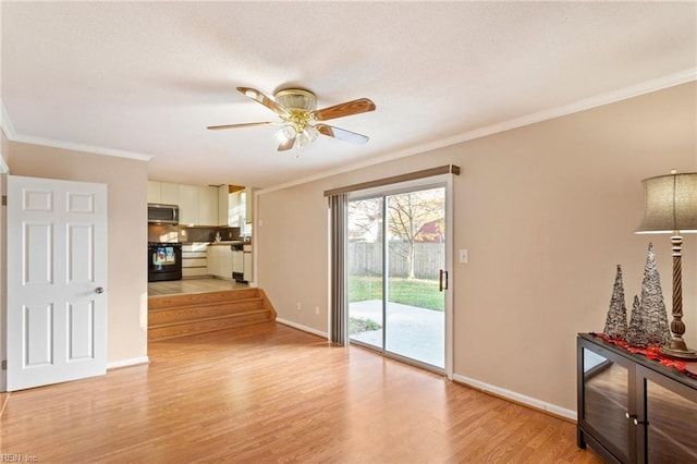 living room with baseboards, a ceiling fan, light wood-style flooring, and crown molding