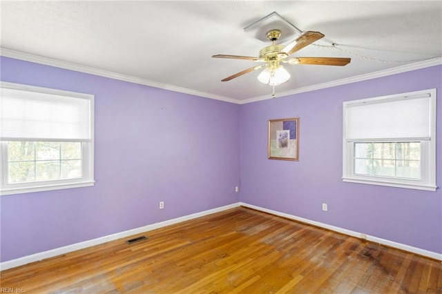 spare room with visible vents, baseboards, a healthy amount of sunlight, and ornamental molding