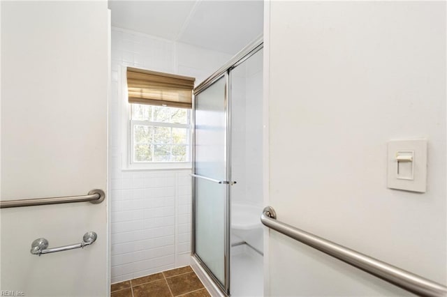 bathroom with tile patterned floors, an enclosed shower, and tile walls