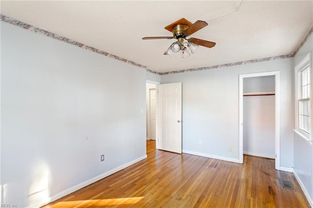 unfurnished bedroom featuring a closet, visible vents, baseboards, and hardwood / wood-style flooring