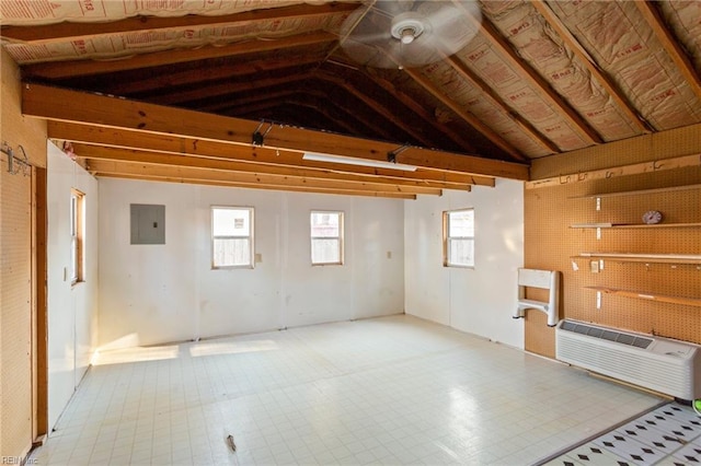 unfurnished room with electric panel, lofted ceiling, and a wall mounted AC