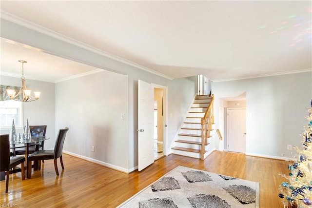 interior space with a notable chandelier, wood finished floors, stairs, and crown molding