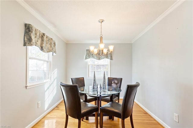 dining space with baseboards, plenty of natural light, a notable chandelier, and light wood finished floors