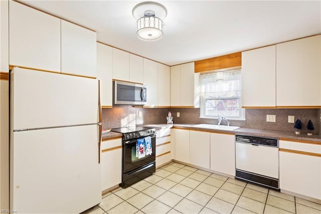 kitchen featuring a sink, white appliances, backsplash, and light tile patterned floors