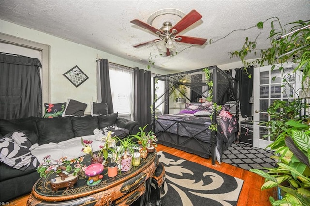 bedroom featuring a textured ceiling, wood finished floors, and a ceiling fan