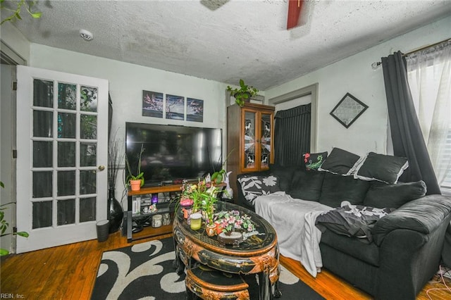 living area with a textured ceiling and wood finished floors