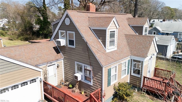 view of property exterior featuring a wooden deck, roof with shingles, cooling unit, a chimney, and a garage