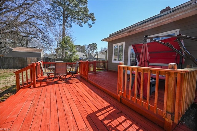 wooden terrace featuring outdoor dining space and fence