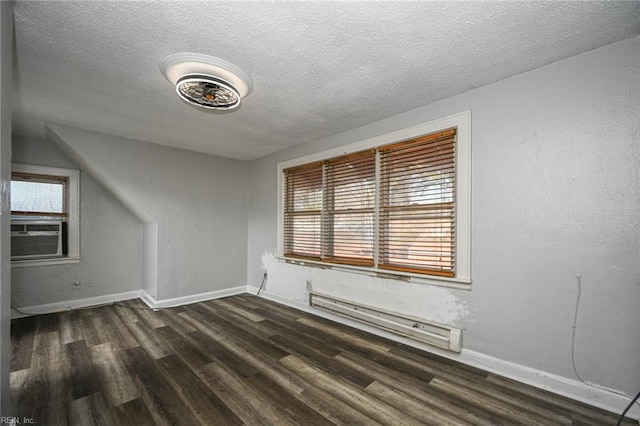 additional living space featuring a textured ceiling, cooling unit, a baseboard radiator, baseboards, and dark wood-style flooring