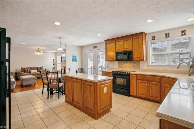 kitchen featuring brown cabinets, black appliances, a sink, french doors, and light countertops