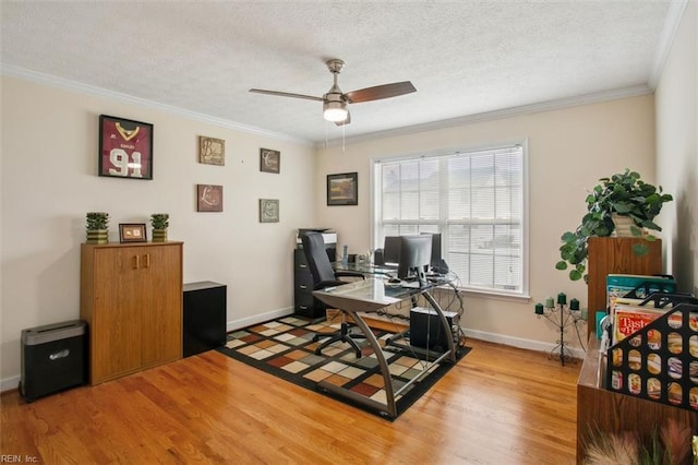 office featuring baseboards, light wood-style flooring, ceiling fan, a textured ceiling, and crown molding