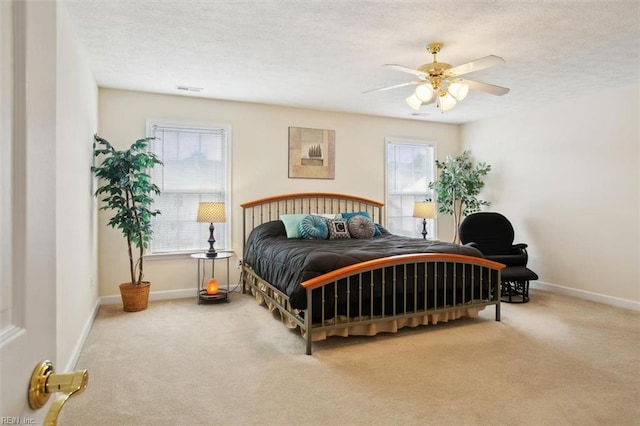 carpeted bedroom featuring baseboards, a textured ceiling, and ceiling fan