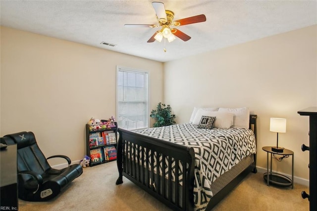 carpeted bedroom featuring visible vents, baseboards, and ceiling fan