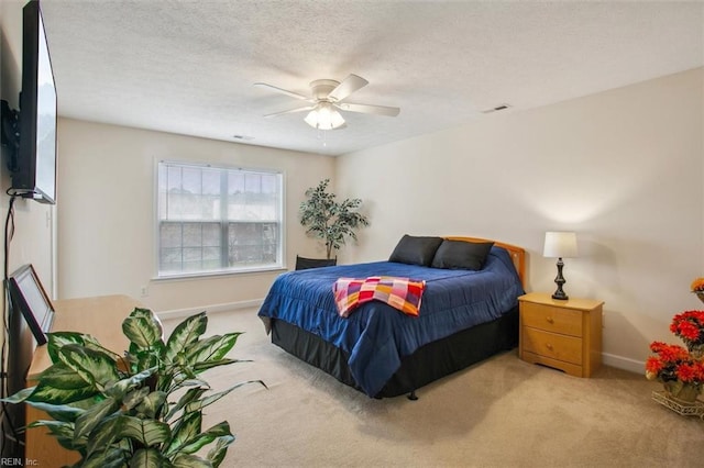 carpeted bedroom with a ceiling fan, baseboards, visible vents, and a textured ceiling