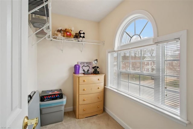 spacious closet featuring light colored carpet