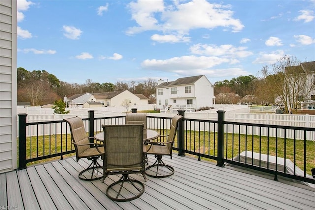 wooden deck with outdoor dining area, a residential view, a yard, and a fenced backyard