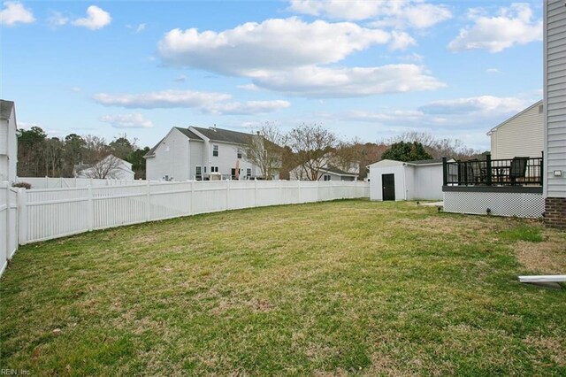 view of yard featuring an outbuilding, a storage unit, and a fenced backyard