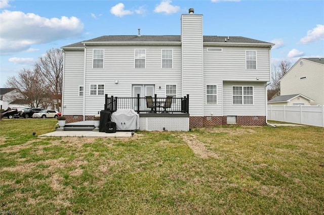 back of house with a patio, fence, a wooden deck, a chimney, and a lawn