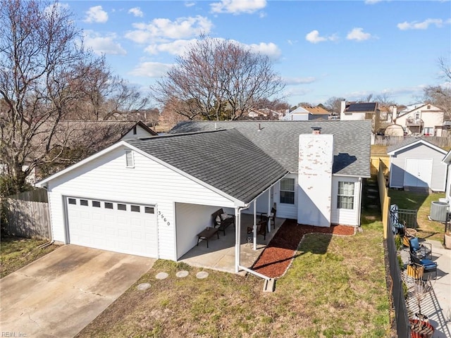 view of front facade with a front lawn, fence, roof with shingles, a garage, and driveway