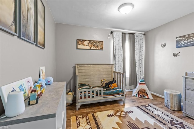 bedroom featuring baseboards and wood finished floors