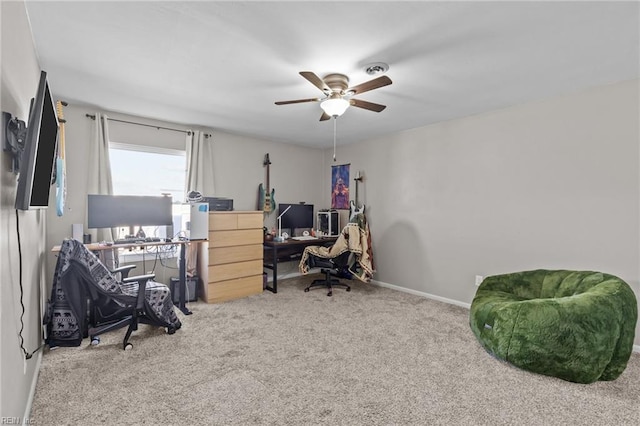 carpeted office featuring a ceiling fan and baseboards