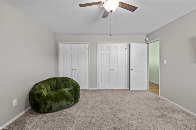 sitting room featuring baseboards, carpet, and ceiling fan