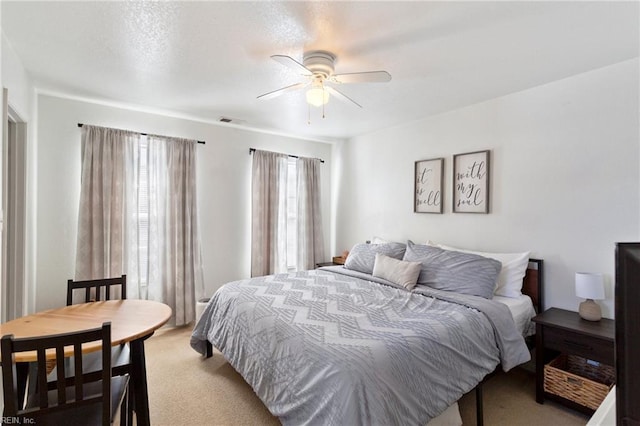 bedroom featuring visible vents, light carpet, and ceiling fan