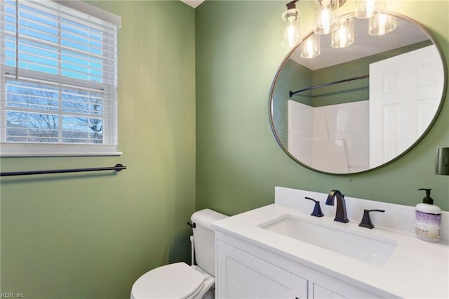 bathroom featuring toilet, a chandelier, and vanity