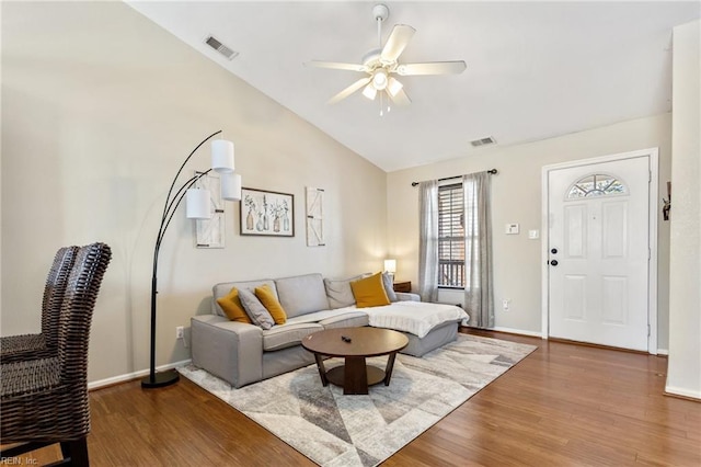 living room with visible vents, lofted ceiling, a ceiling fan, and wood finished floors