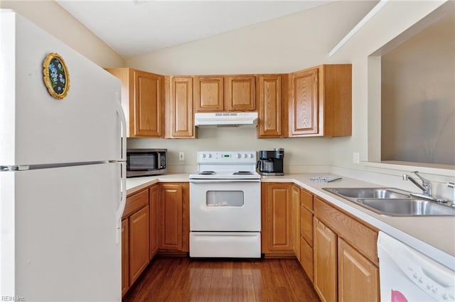 kitchen featuring under cabinet range hood, light countertops, vaulted ceiling, white appliances, and a sink