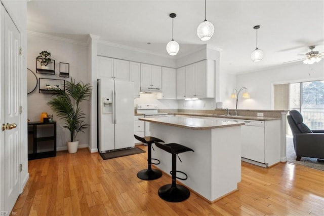 kitchen featuring white cabinets, white appliances, light wood-style flooring, and a peninsula