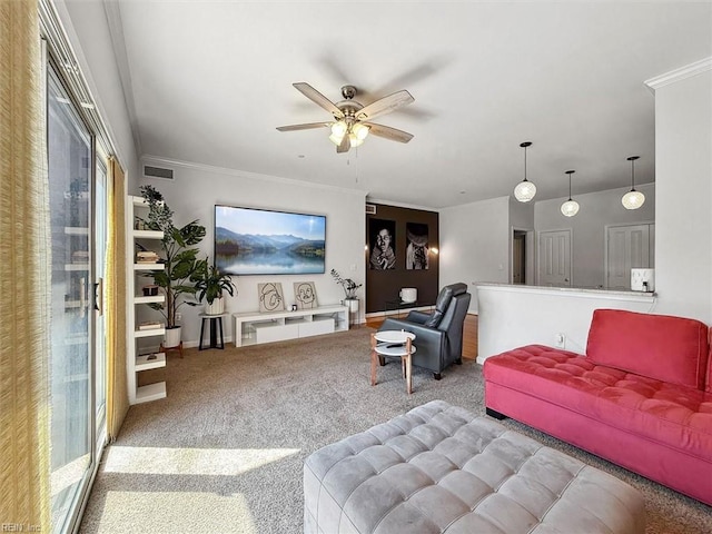 living area with visible vents, ornamental molding, carpet floors, baseboards, and ceiling fan