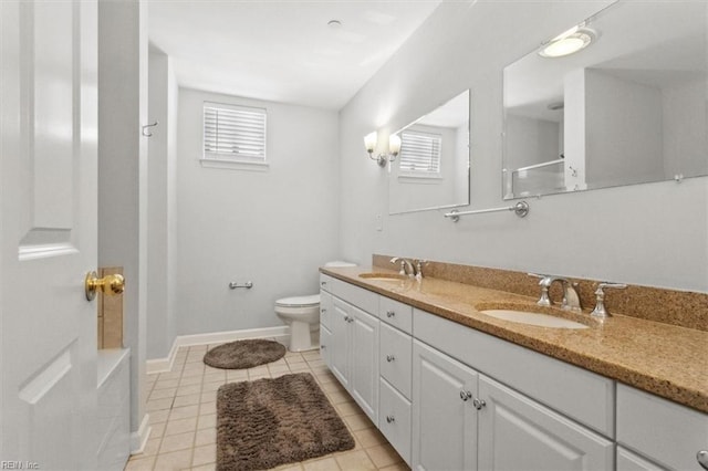 full bathroom with a sink, baseboards, toilet, and double vanity