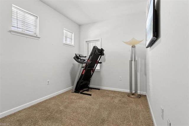 workout area featuring baseboards and carpet floors